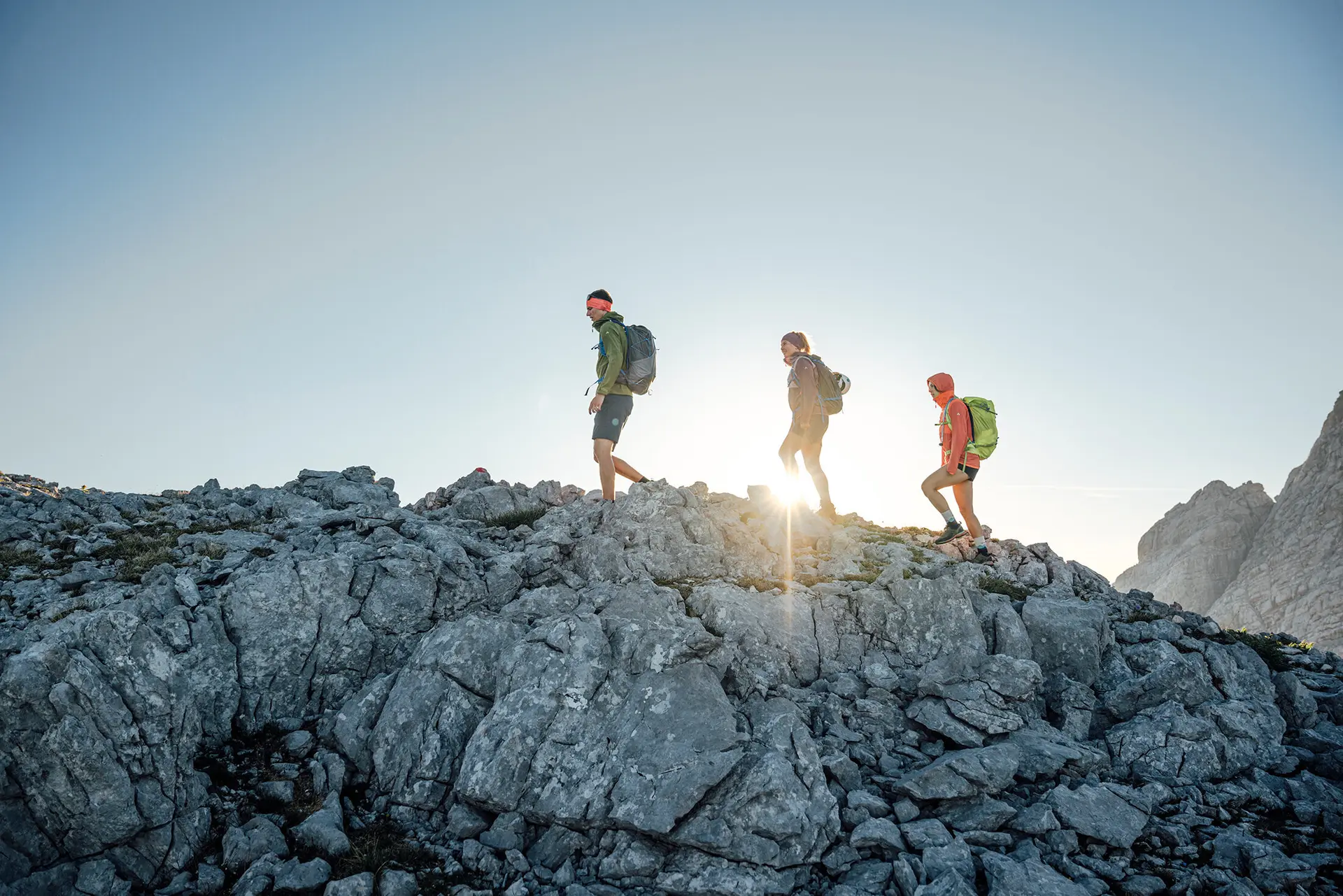 Drei Persinen besteigen im Sonnenaufgang einen Gipfel | © DAV / Julian Rohn
