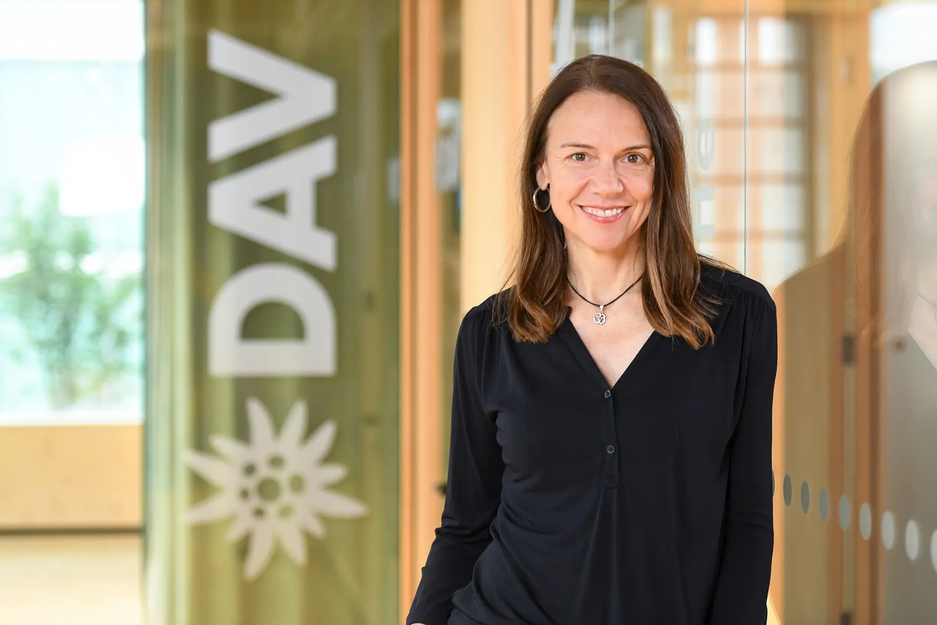 Geschäftsführerin Andrea Händel - fotografiert vor dem DAV-Logo | © DAV/Tobias Hase